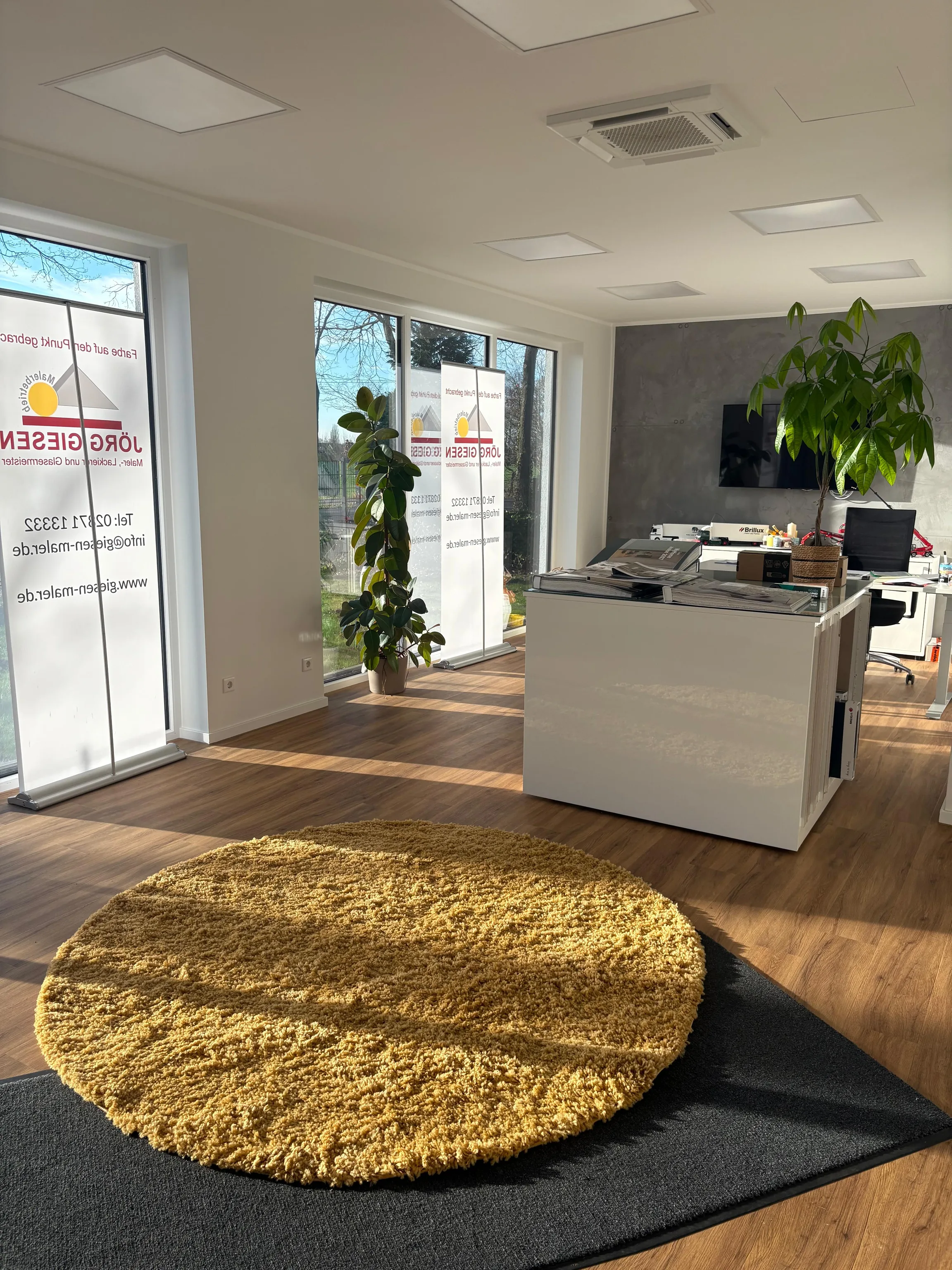 Innenansicht der Firmenzentrale mit Empfangstresen und großen Fenstern